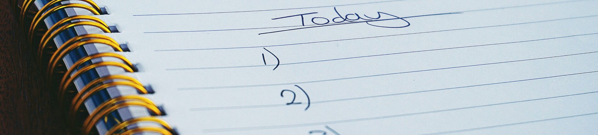 A close-up view of a handwritten to-do list on a spiral notebook with numbers for tasks.