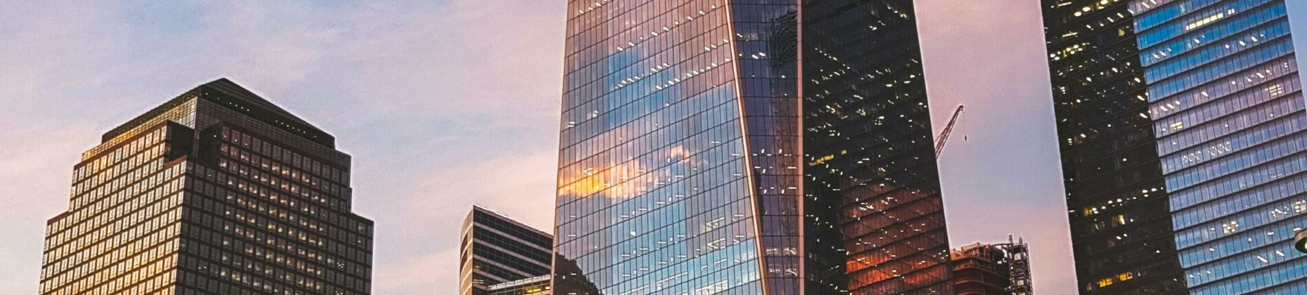 One World Trade Center reflecting sunset hues in New York City skyline.