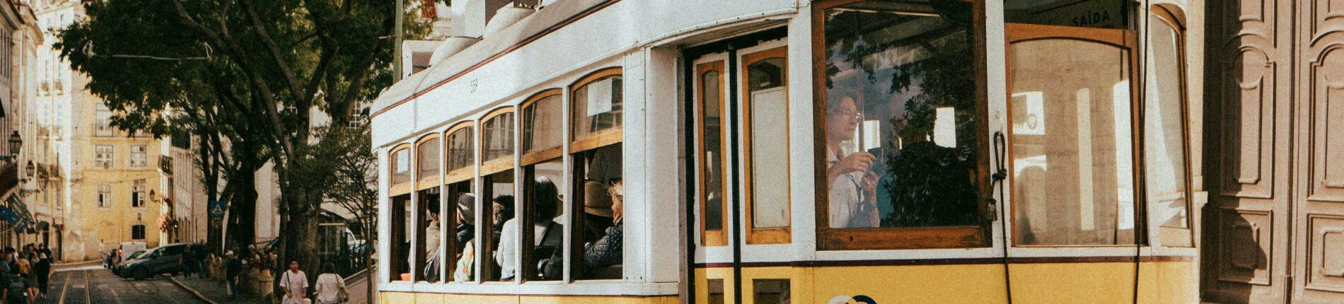 Iconic yellow tram travels through the historic streets of Lisbon, Portugal.