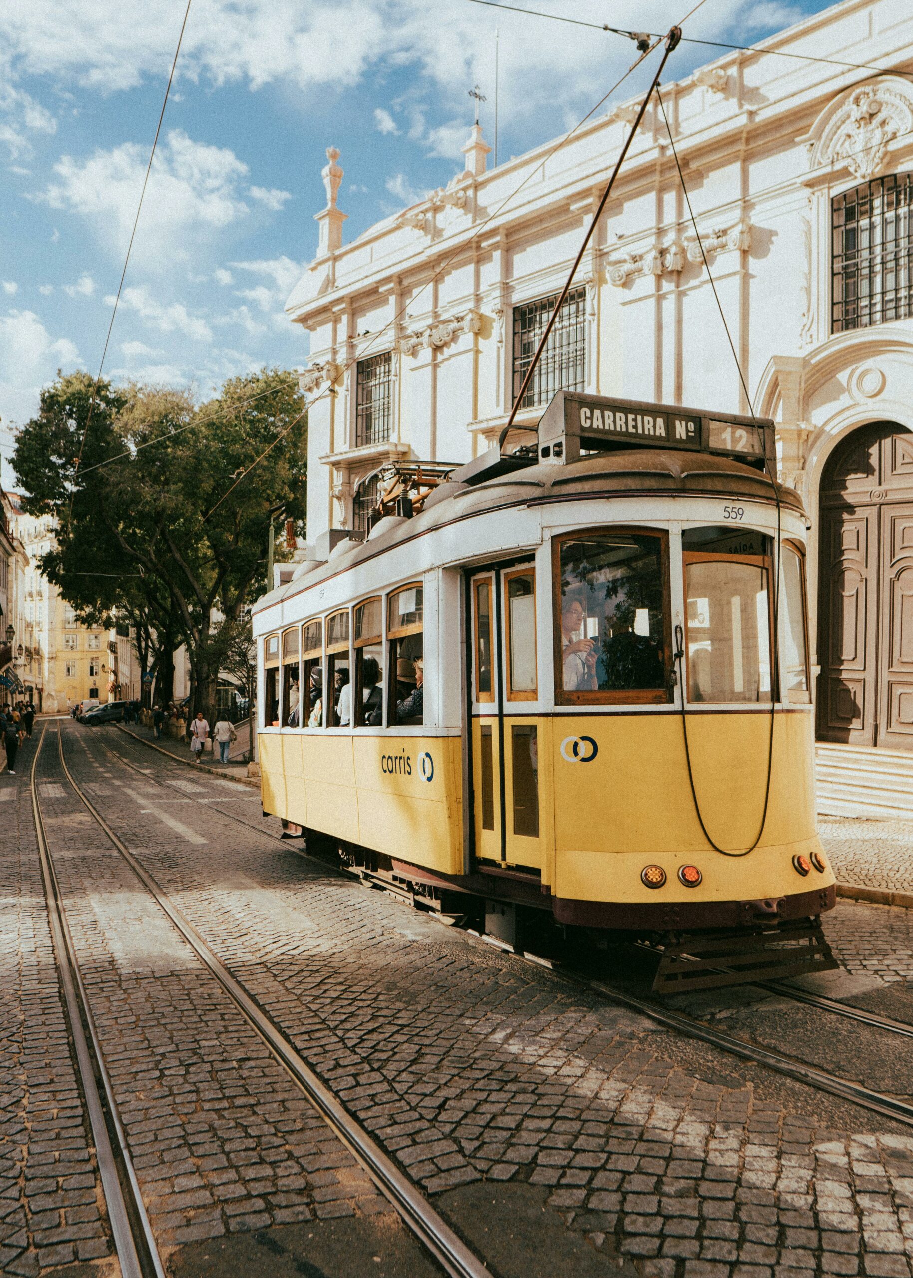 Iconic yellow tram travels through the historic streets of Lisbon, Portugal.