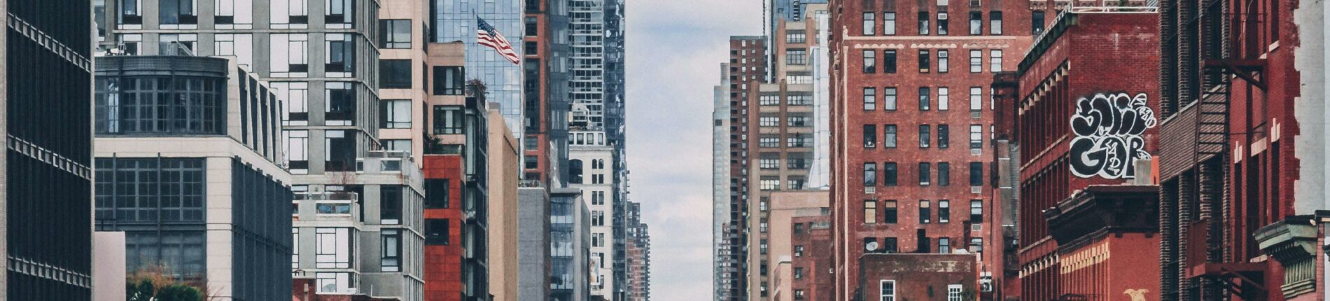 Bustling street scene in NYC with iconic skyscrapers and busy traffic.