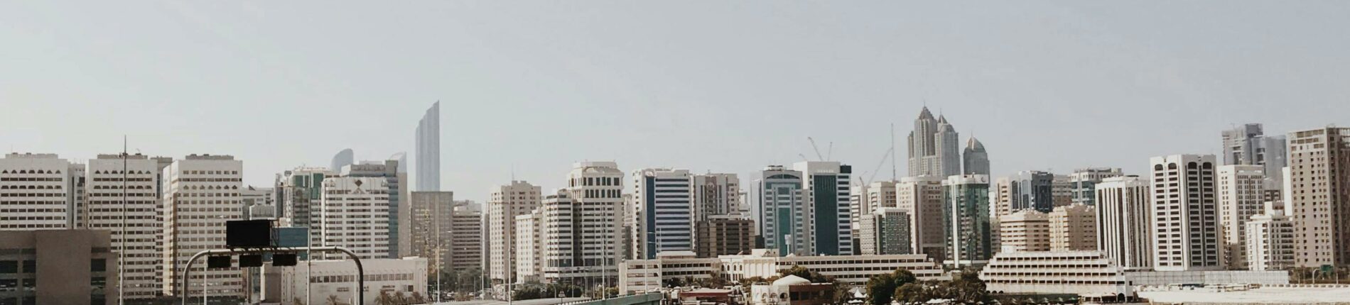 Explore the dynamic cityscape of Abu Dhabi featuring a modern bridge and skyline over tranquil waters.