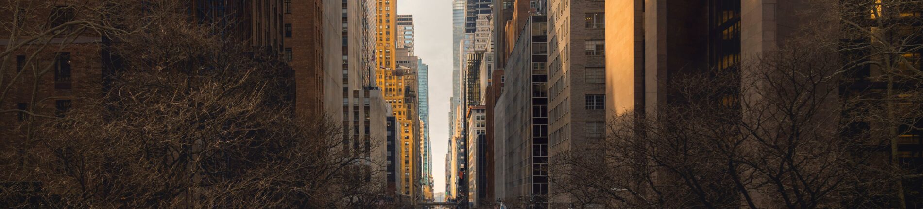 A bustling New York City street featuring yellow taxis, modern skyscrapers, and iconic architecture.