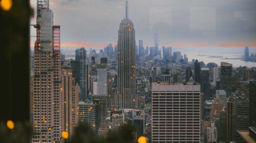View of New York City skyline with Empire State Building through holiday decor. Perfect for travel and winter imagery.