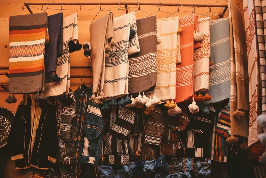 Vibrant Moroccan textiles on display in Agadir market with rich patterns.