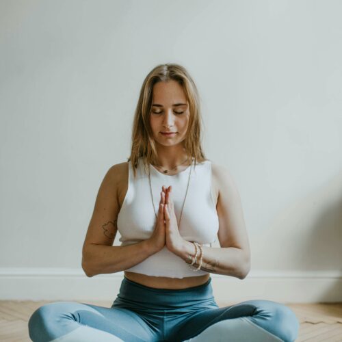 A serene image of a woman practicing meditation indoors, promoting mindfulness and wellbeing.