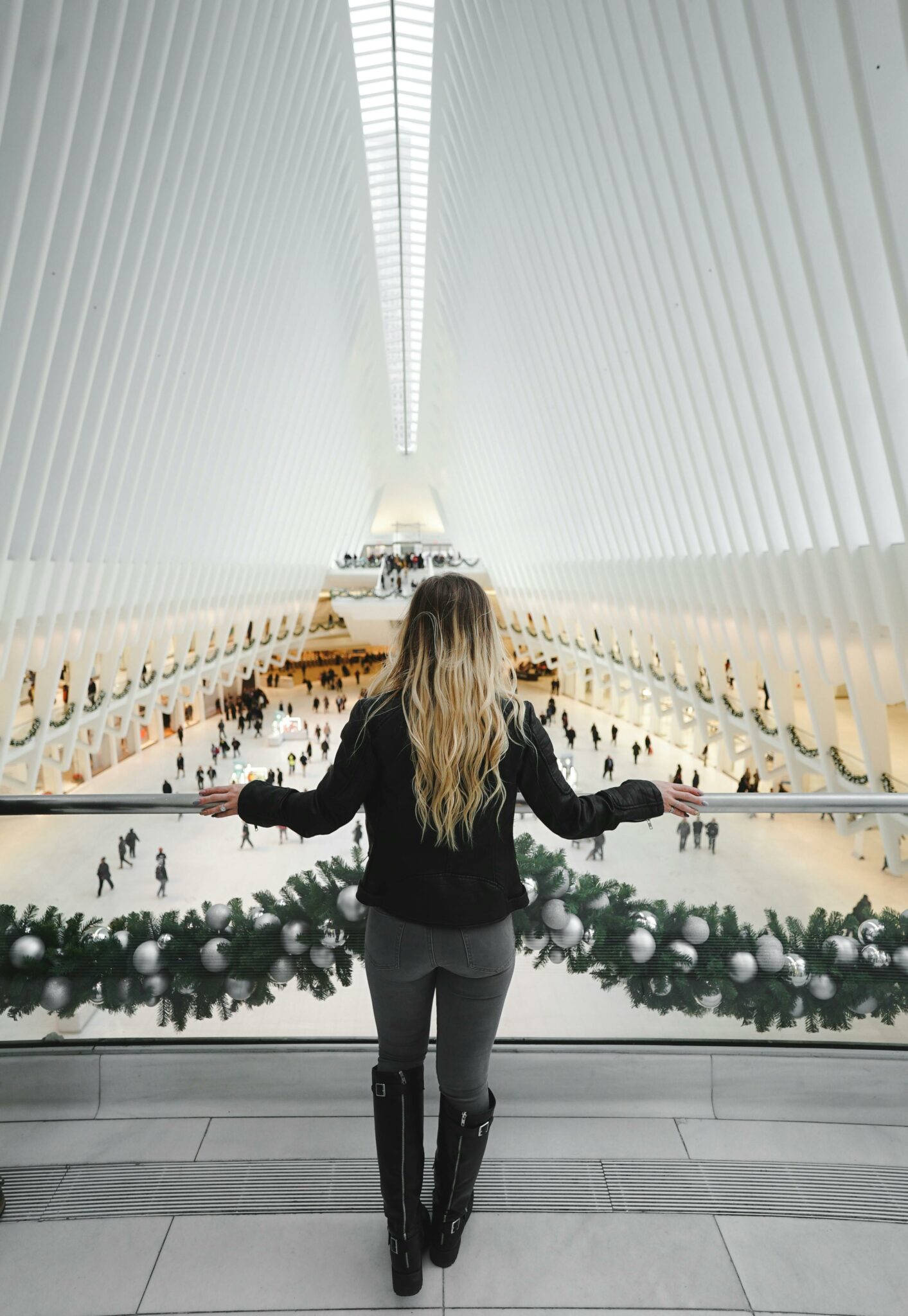 A woman overlooks the stunning interior design of the Oculus in New York City during winter.