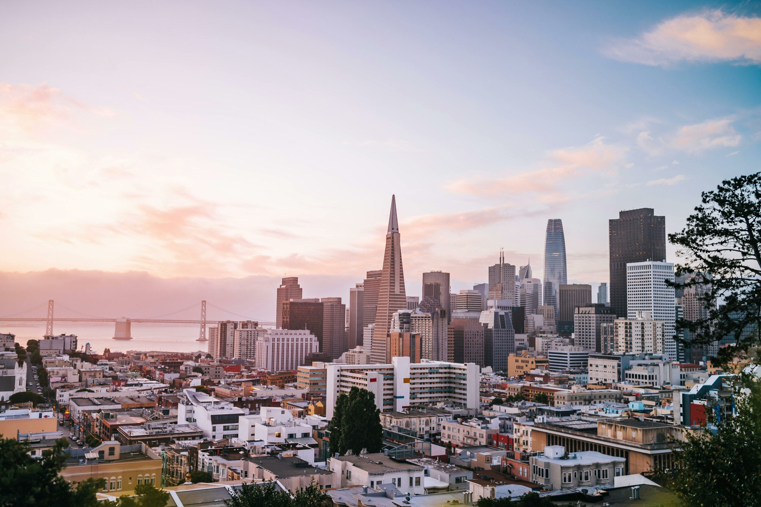 Stunning view of San Francisco cityscape with iconic landmarks during sunrise.