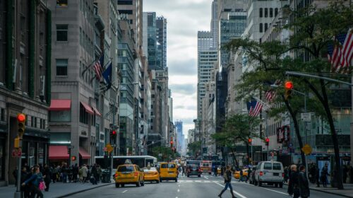 Vibrant street view of New York City with pedestrians, yellow cabs, and skyscrapers.