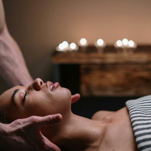 A woman enjoying a relaxing face massage in a tranquil spa setting.