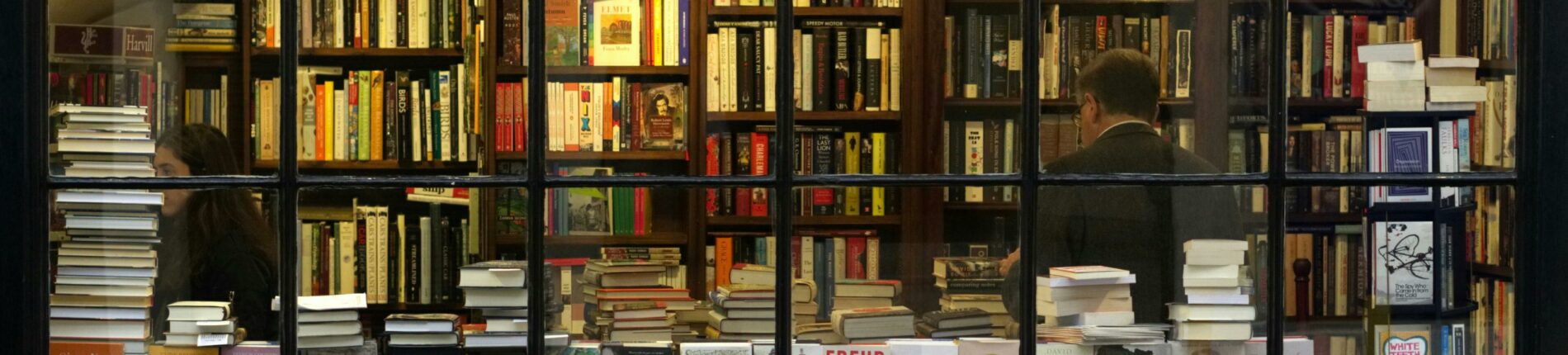 A cozy London bookstore showcasing various books through a classic window display.