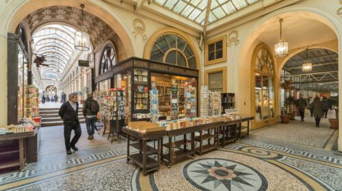A picturesque Parisian shopping arcade showcasing vintage bookstores and mosaic floors.
